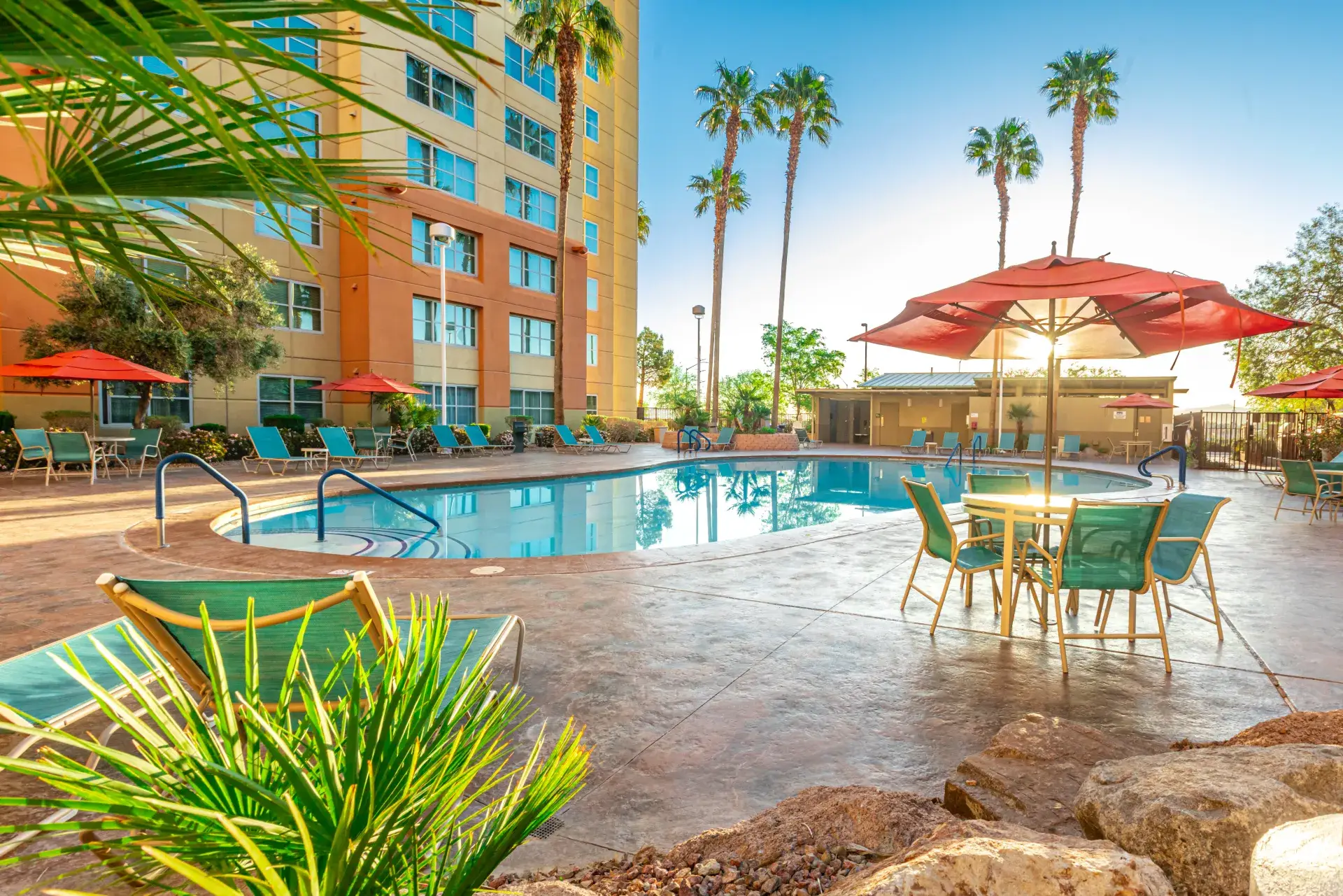 Resort pool with red umbrellas and palm trees at The Grandview at Las Vegas