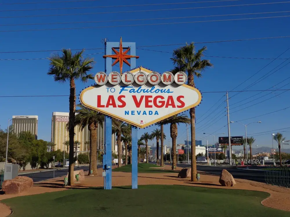 The "Welcome to Fabulous Las Vegas" sign with palm trees and the Strip in the background