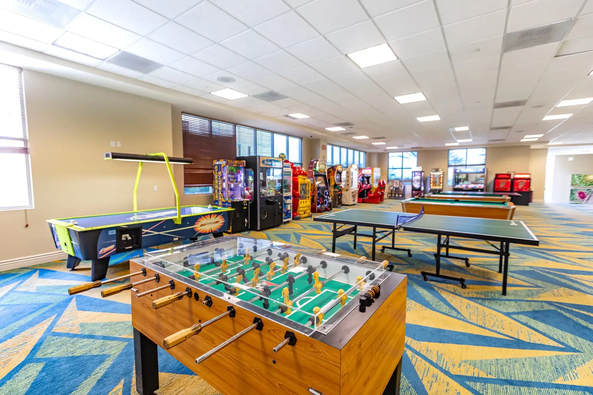 Sala de jogos e arcade com pebolim, hóquei de mesa e máquinas de arcade