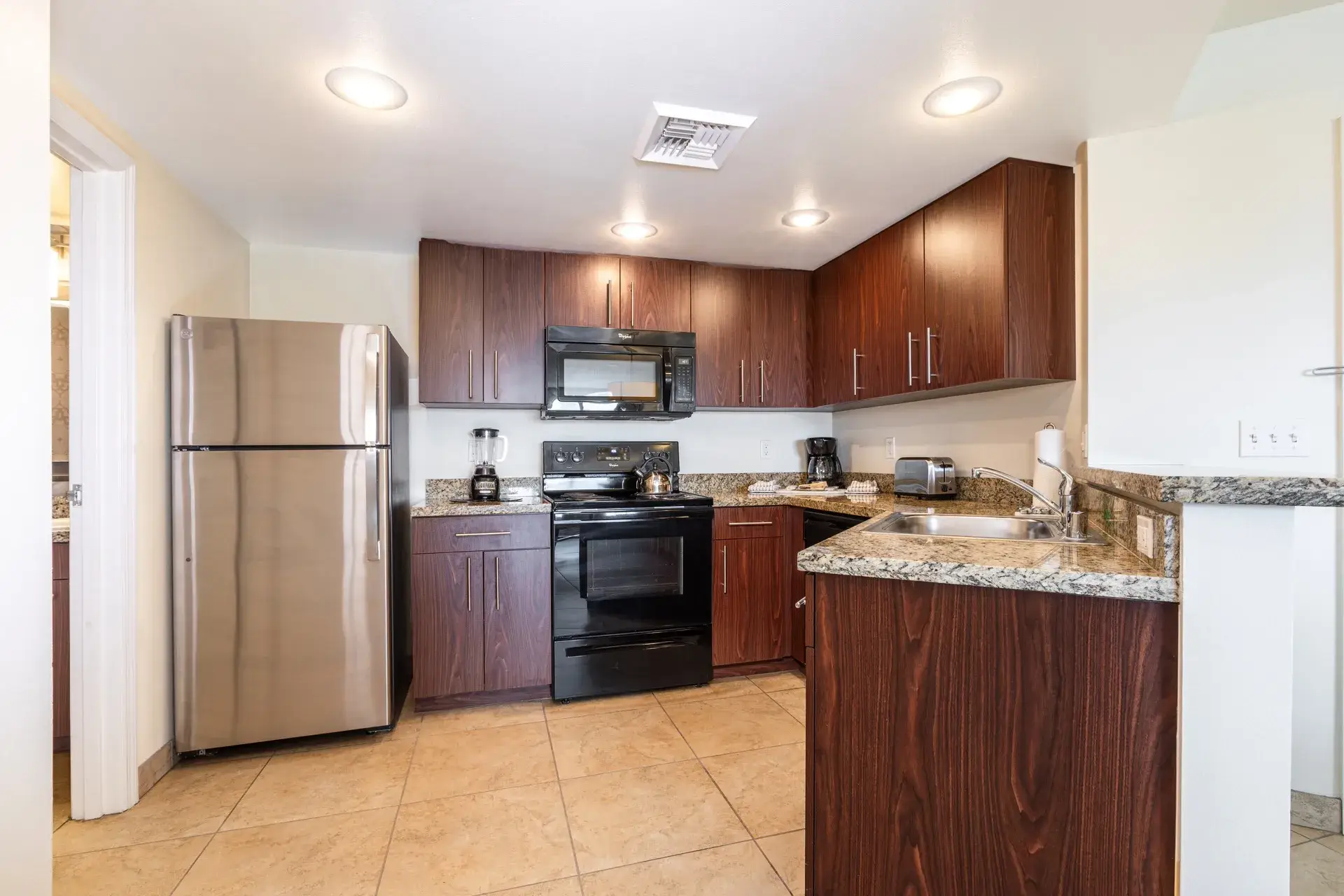 A kitchen with full-size refrigerator, stove, microwave oven, and dishwasher